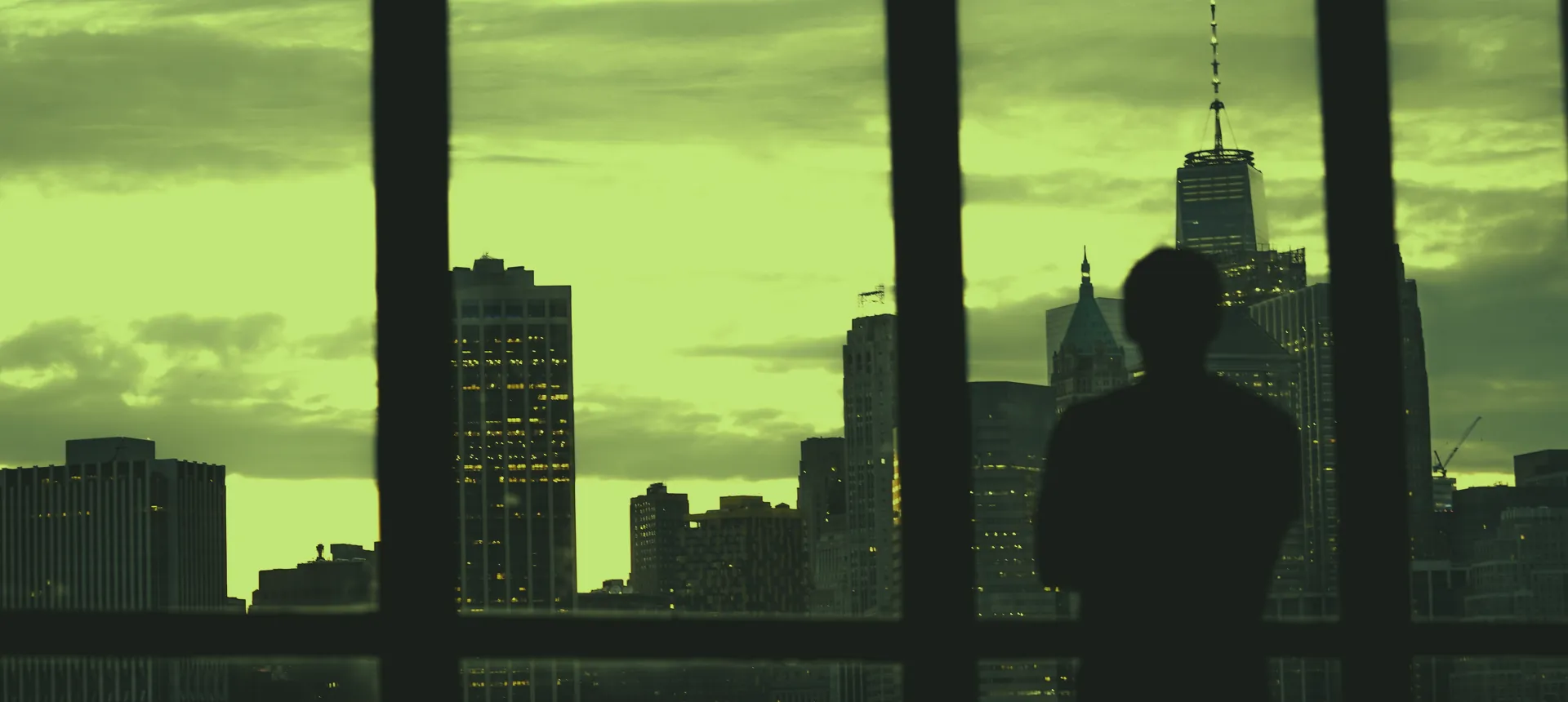 Executivo diante do skyline urbano ao anoitecer